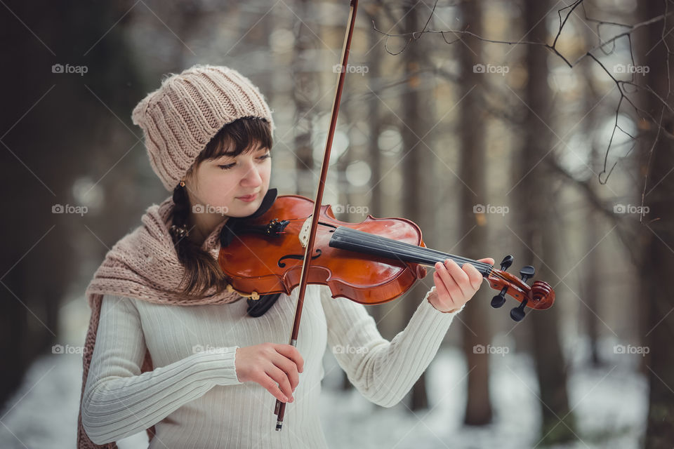 Teenage girl portrait with violin in winter park