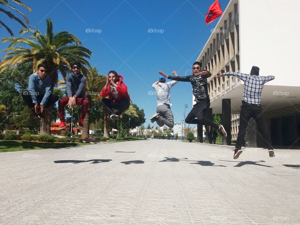 Group of young friends jumping in city street