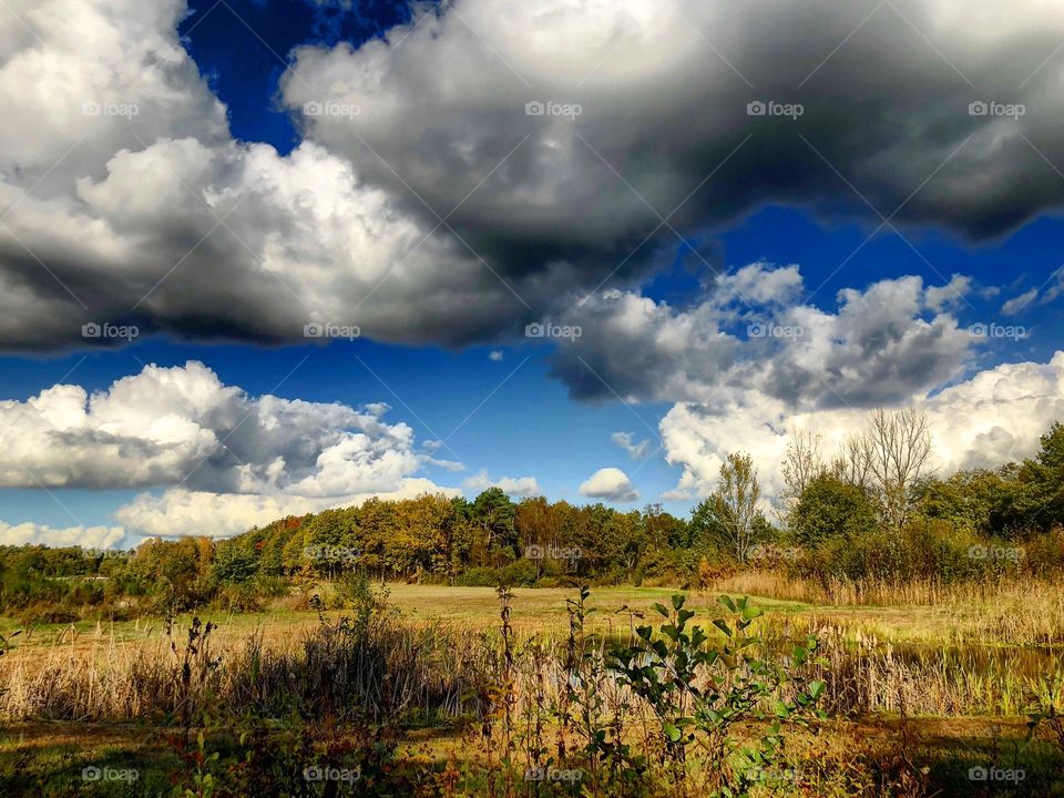 Blue sky and dark clouds over a fall landscape 