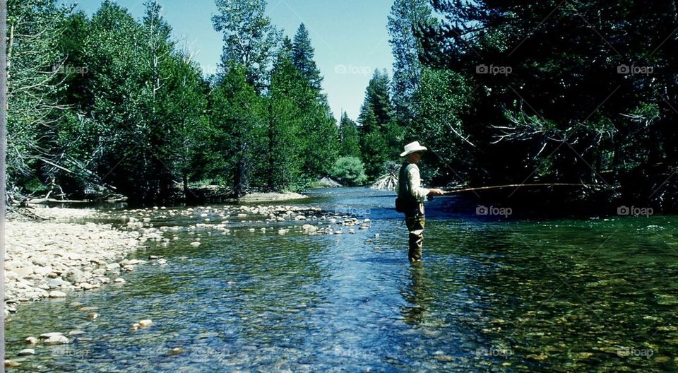 Uncle fishing in river. Beautiful clear water peace of mind