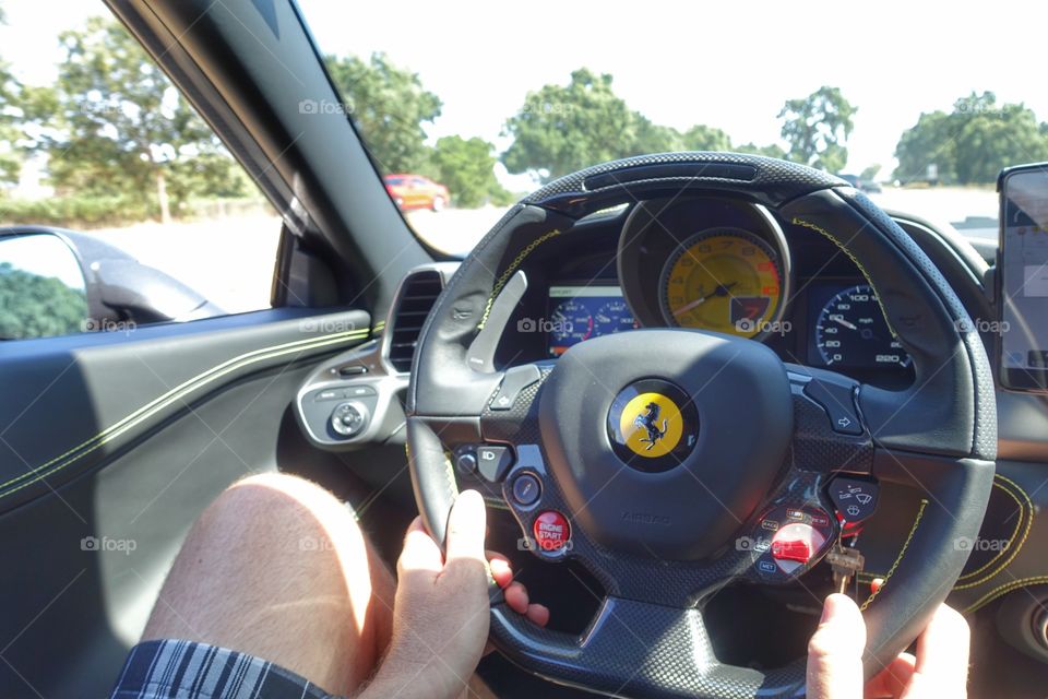 Behind the wheel of the Ferrari taking it for a spin. 