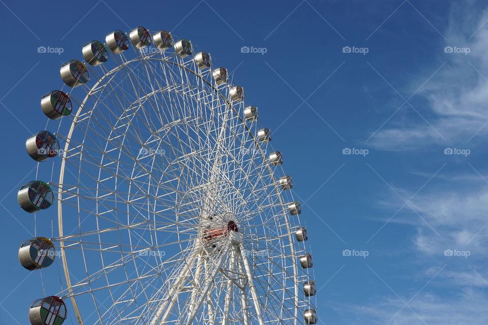 Ferris wheel on a background cloudy sky