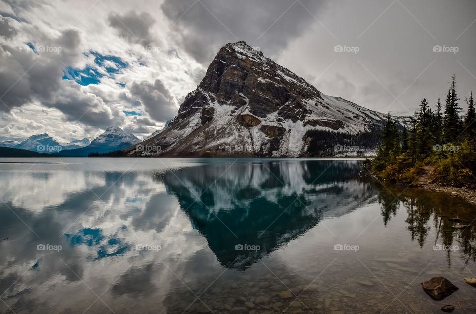 Rocky mountains and clouds reflecting on lake