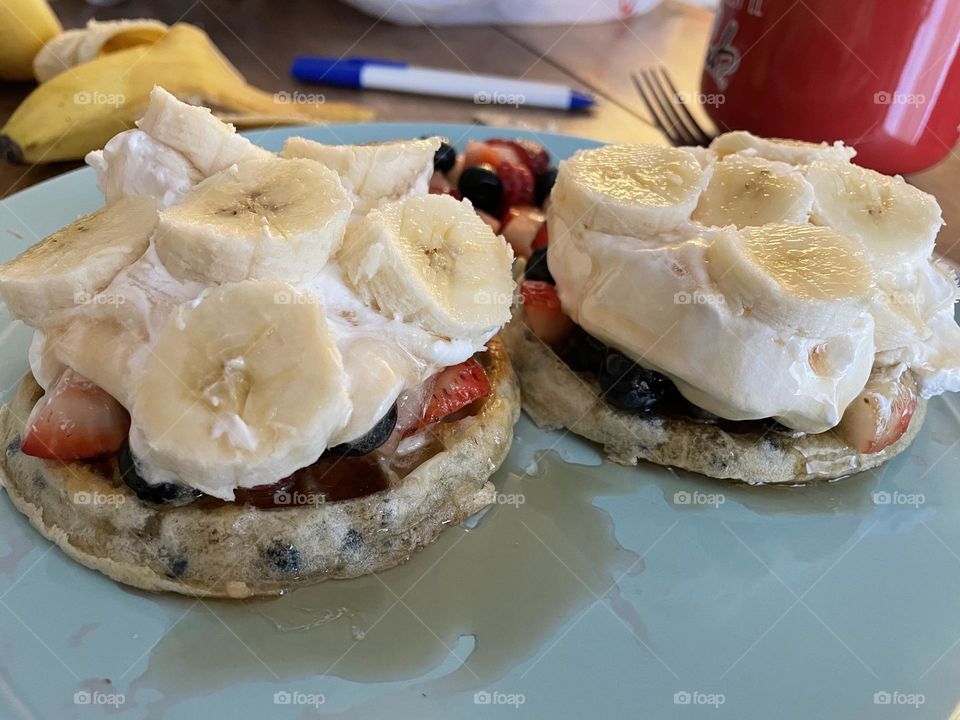 homemade blueberry pancakes for breakfast with mixed fruits and whipping cream on top