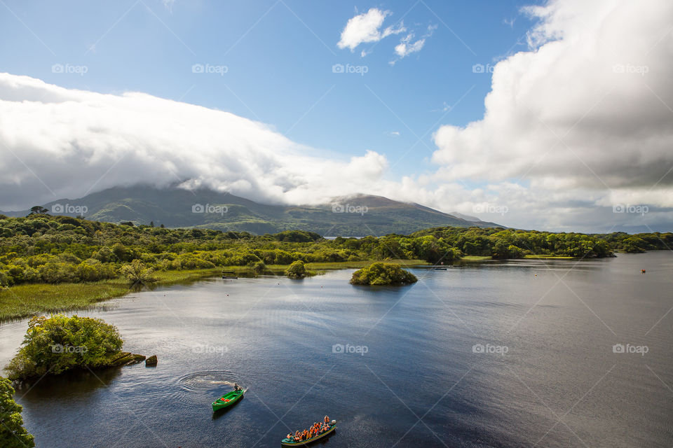 Beautiful nature photo of boats on a lake with blue skies and clouds.