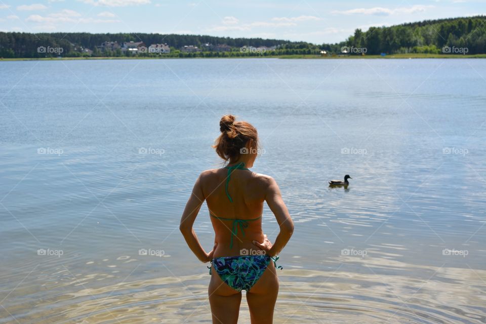 girl in swimsuit resting on a lake summer landscape