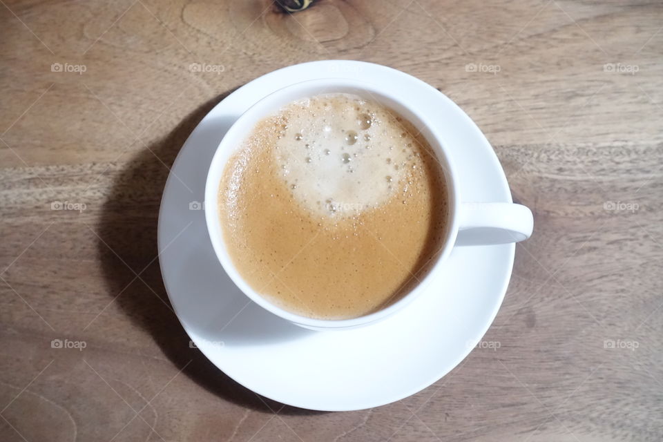 A cup of espresso on the wooden table.
