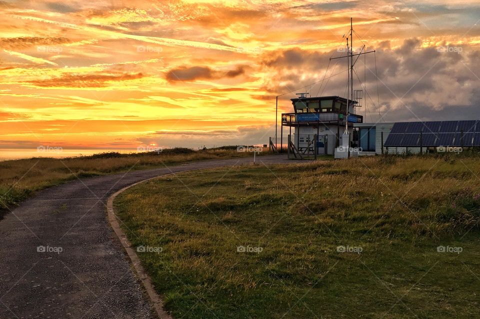 Coast guard lookout station at sunset in Portland. Stunning amber sunset on the south coast UK under the ever watchful eye of the coastguard.