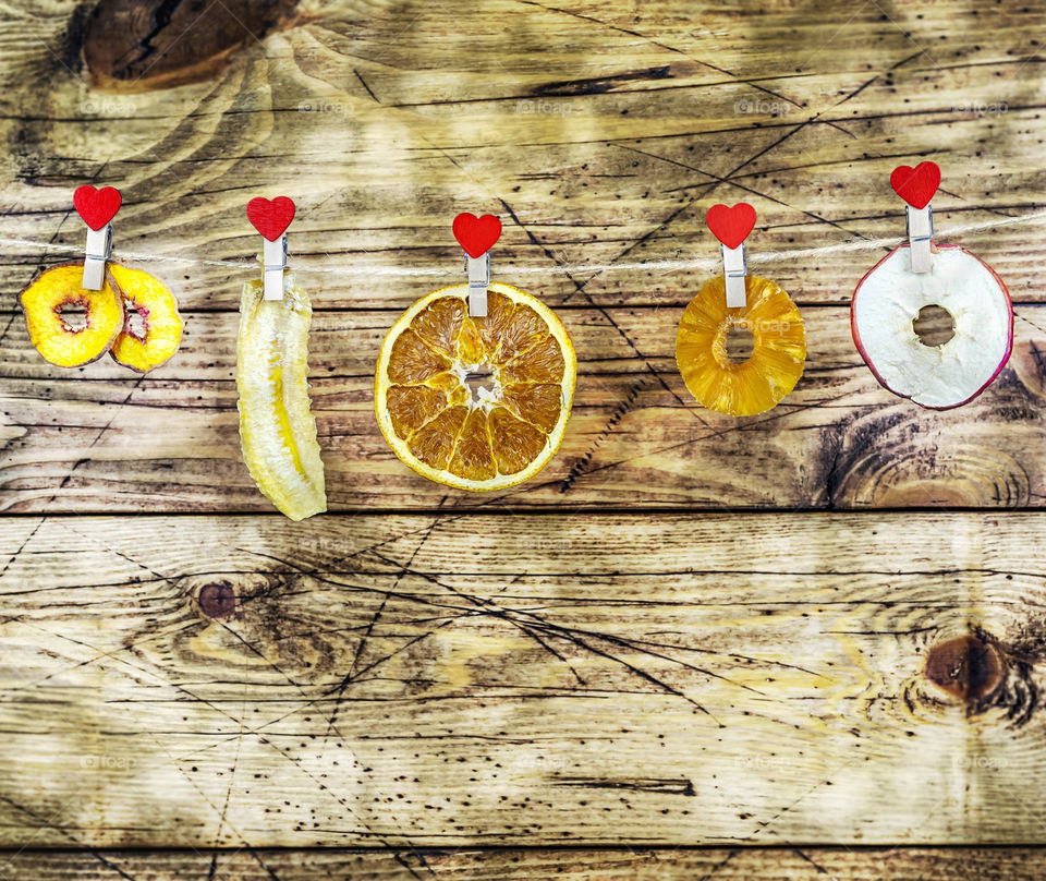 Dry slice fruits apple, banana, orange, pineapple, pear on a wooden background with copy space. Tasty dehydrated mix fruit chips. Trendy food for vegetarian. Food photo