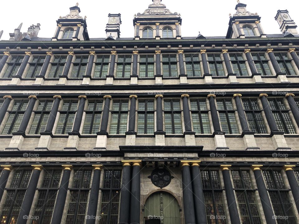 Antique building facade with black columns and details in gold