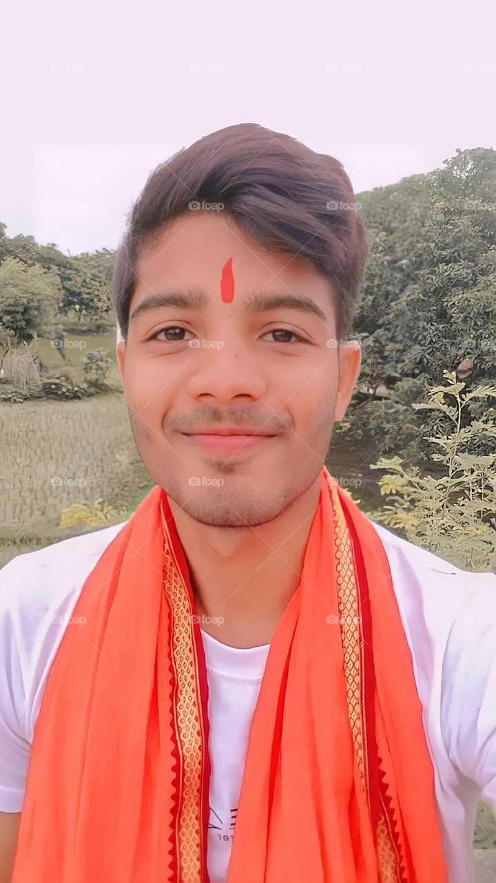 a portrait of Indian boy smiley face with red tilak