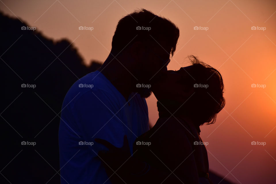 Couple kissing during a sunset