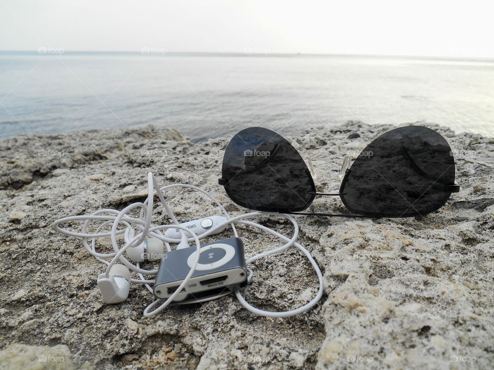 music player favourite on a sea stone shore