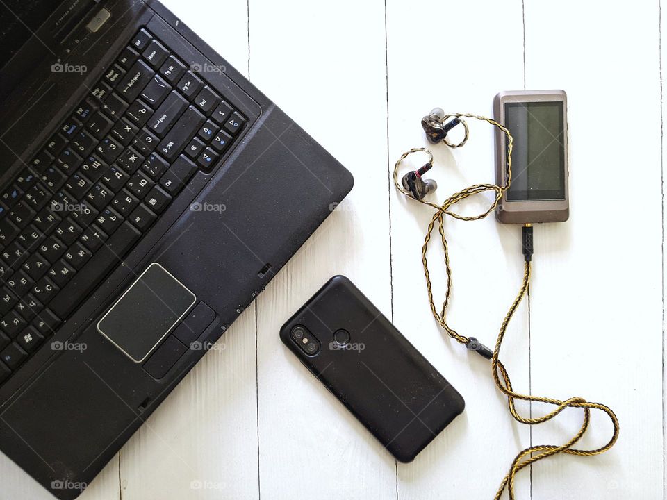 laptop, music player with headphones, smartphone on white background