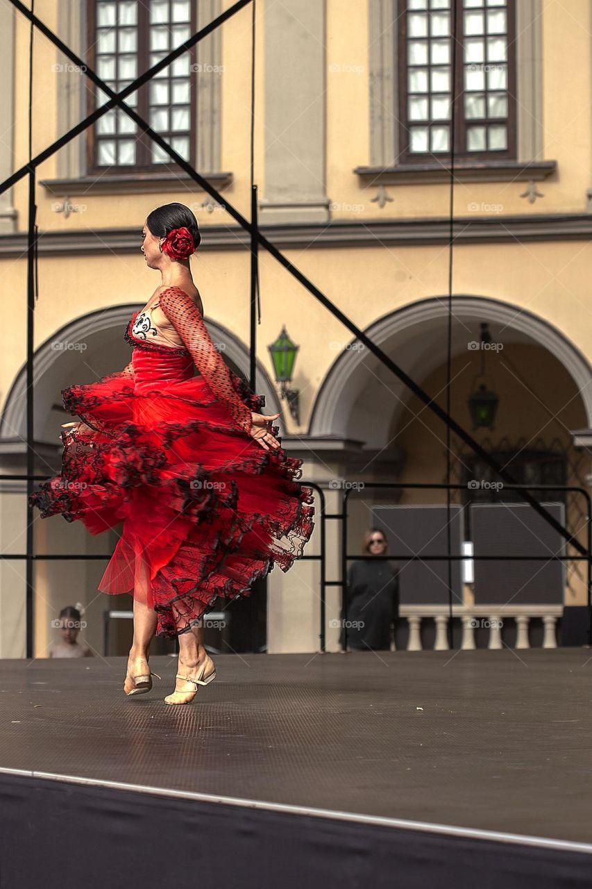 Dancer on an open-air stage, fiery and beautiful dance, red dress, passion.