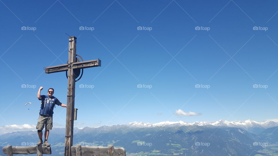 Happy man standing near wooden cross