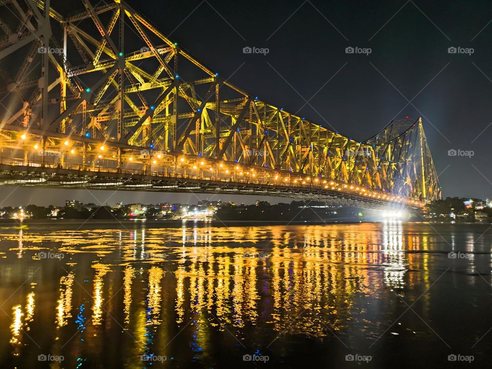 Howrah Bridge upon Ganges river at night