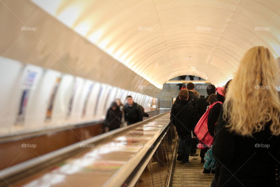 people are moving down and up on the escalators for subway in Paris