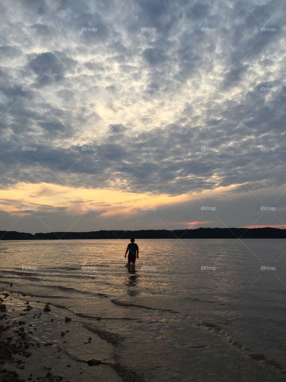 Silhouette of person standing on lake