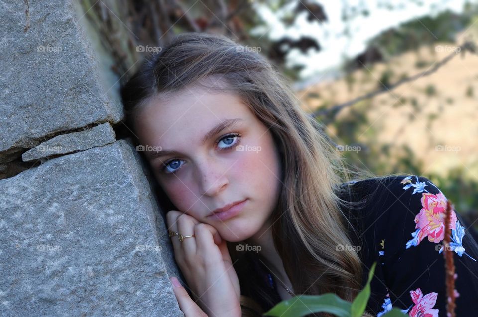 Senior girl leaning against a stone wall!