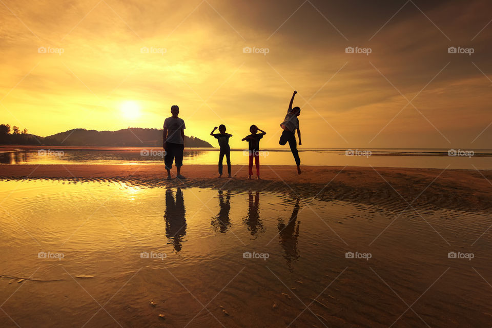Silhouette peoples on the beach with awesome sunrise reflections