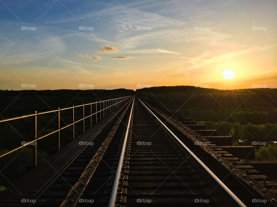 Empty railroad against cloudy sky