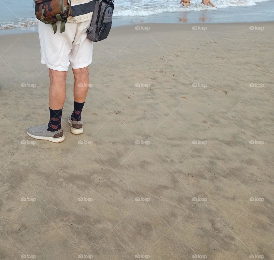 A man standing on the beach in morning time filling fresh air for health wearing white colour half pant it's looking nice