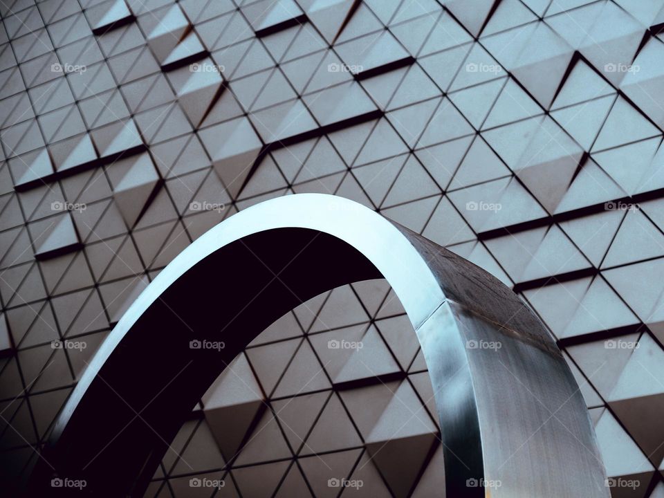 A stainless steel arch in front of an aluminium facade