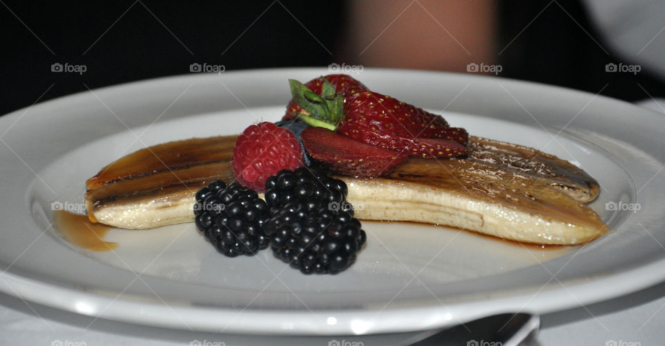 strawberry, blackberry, raspberry and banana dessert on a plate