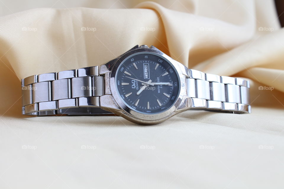 Chrome hand watch on a textile material close-up macro