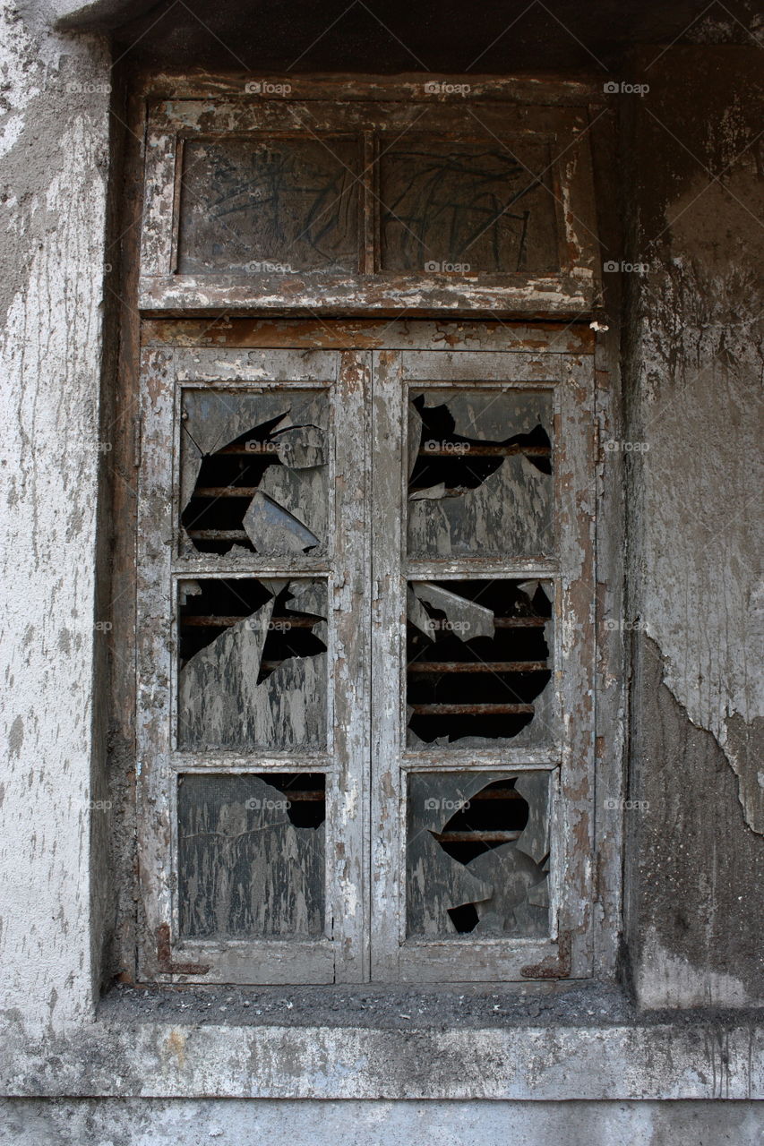 a broken window of abandoned house