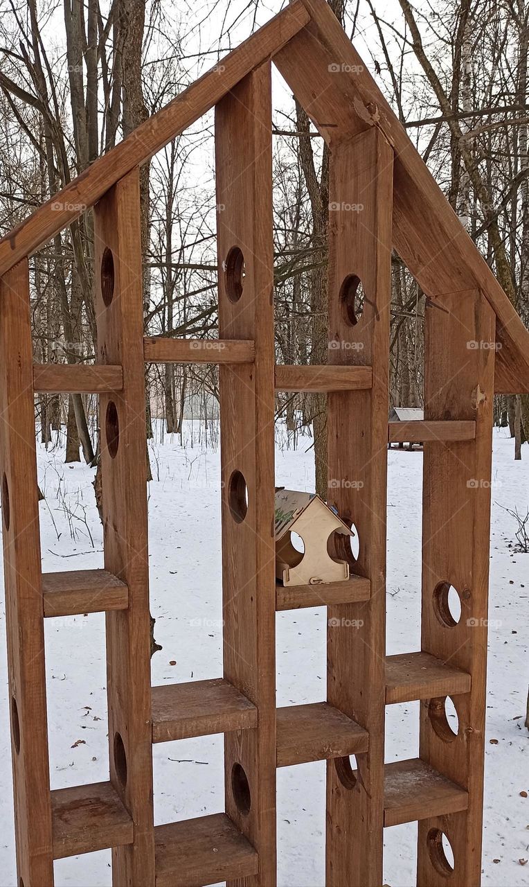 wooden geometric shapes birds house in the winter park