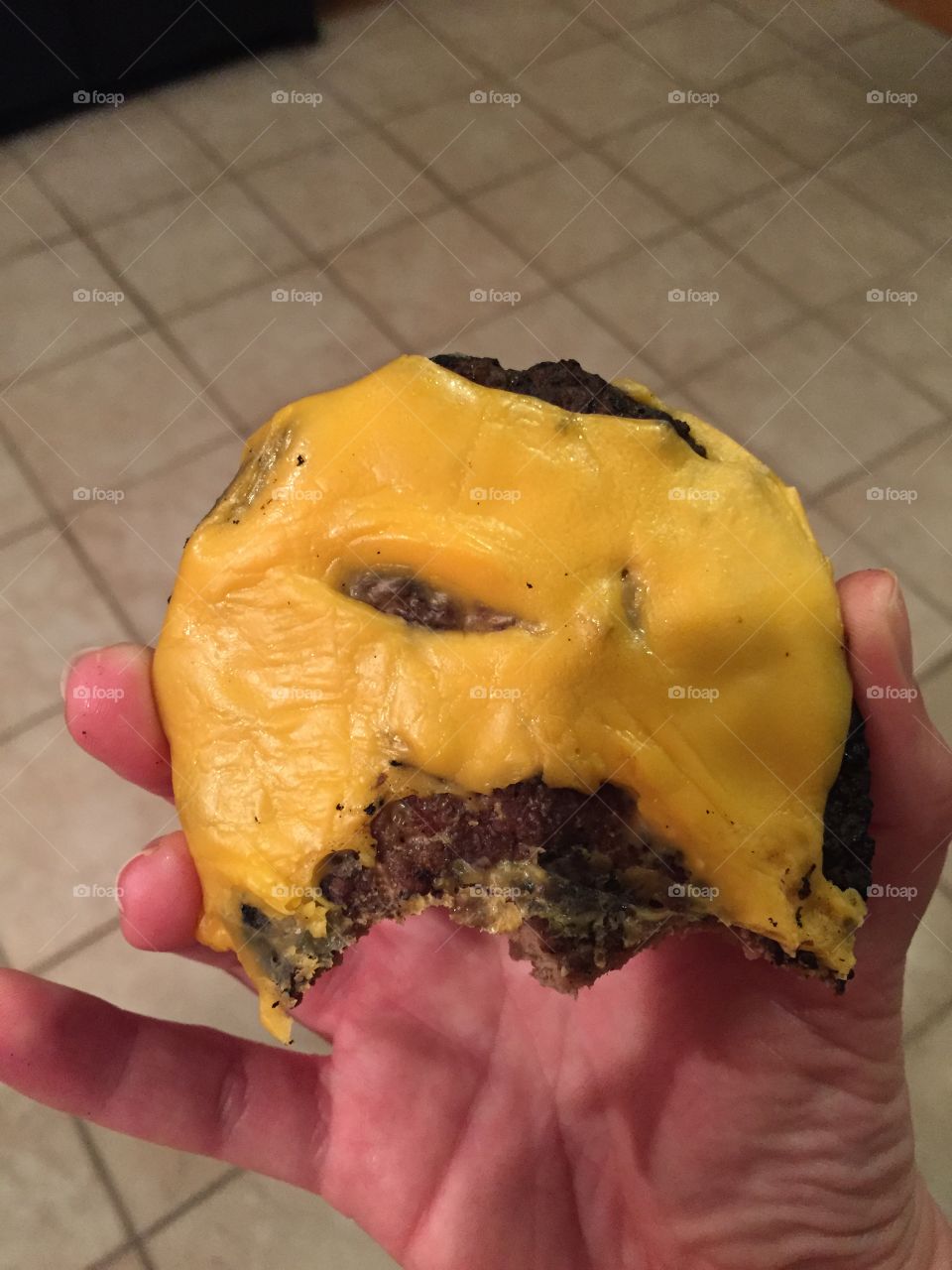 Salty cheeseburger bite. Eating at a party with friends 