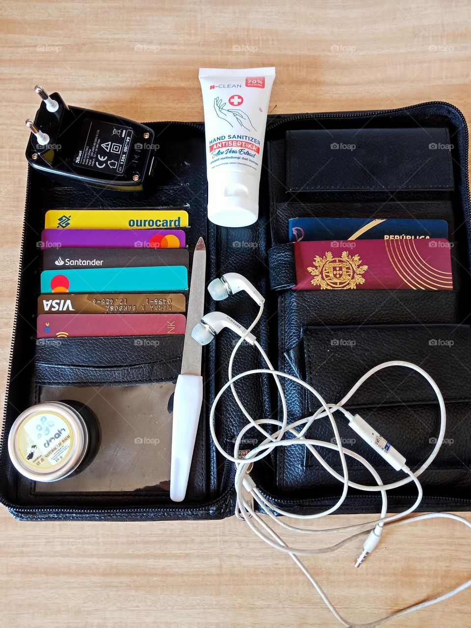 Leather passport holder,  lip balm,  ear phones,  nail file,  charger