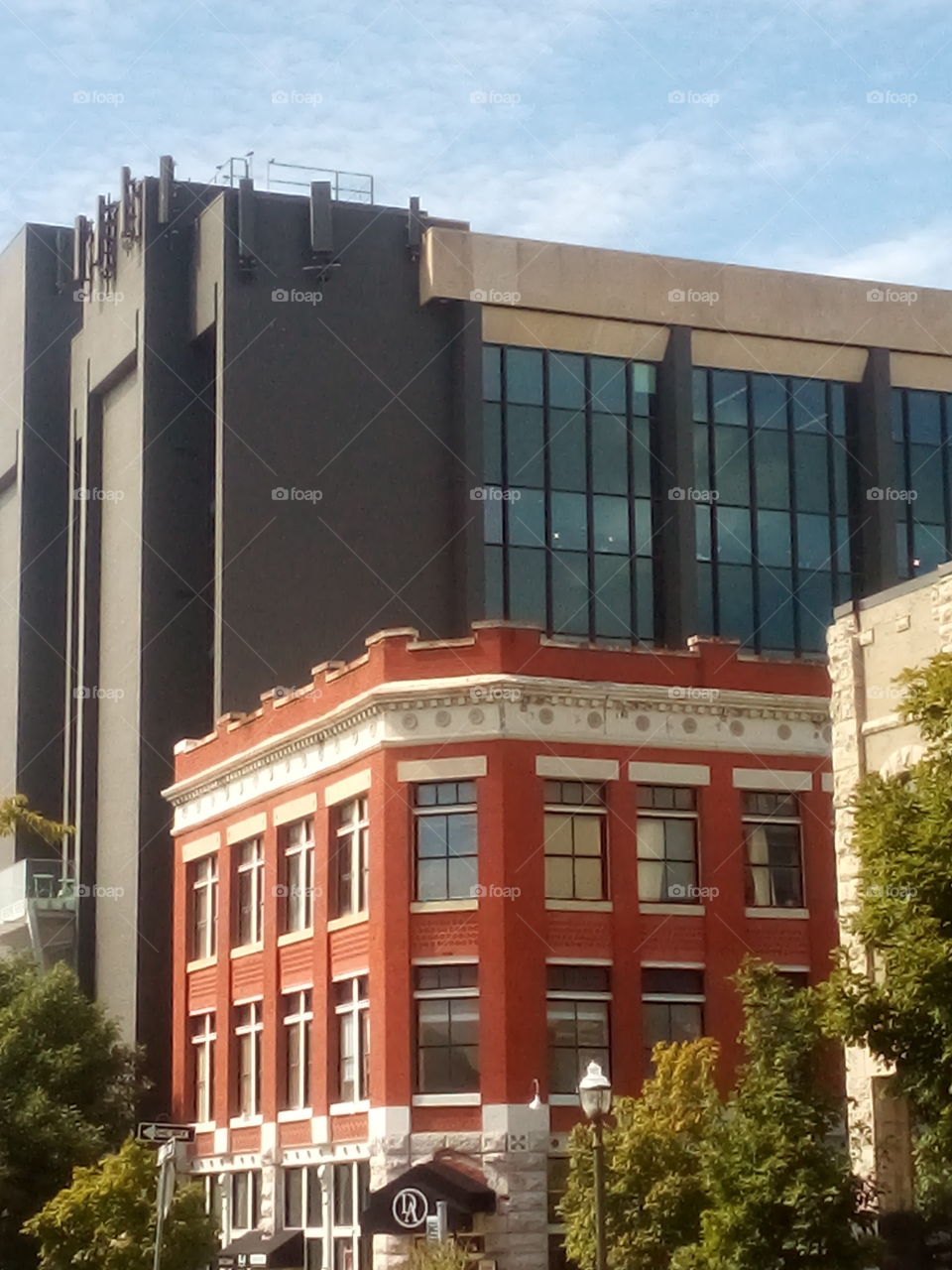 along side the new modern building is an old vintage red brick building.up on the square.