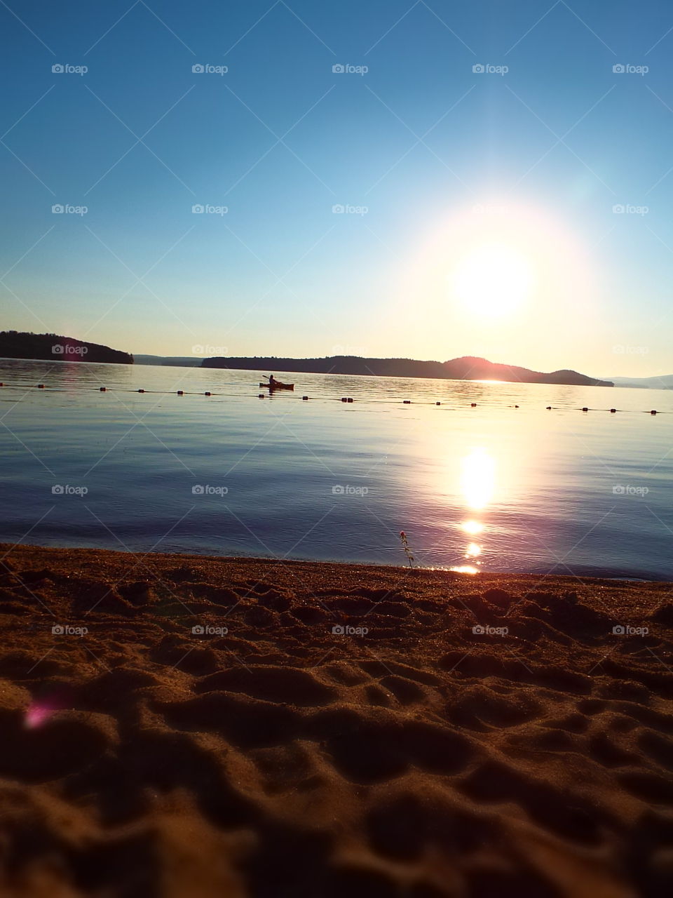 Low angle view of kayak paddling on lake near beach at sunset