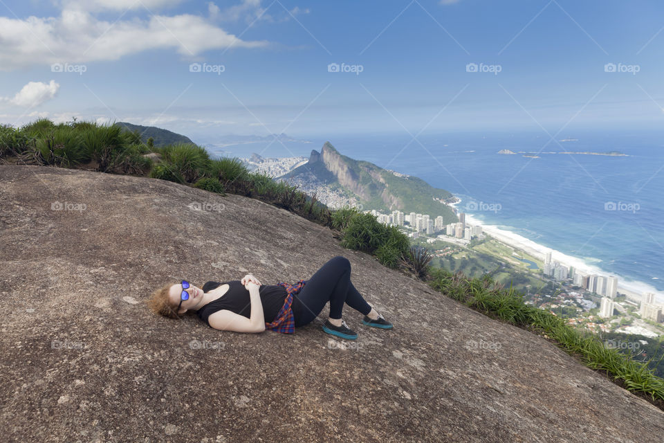 Young millennial woman enjoying the view at the top of the mountain in Rio de Janeiro