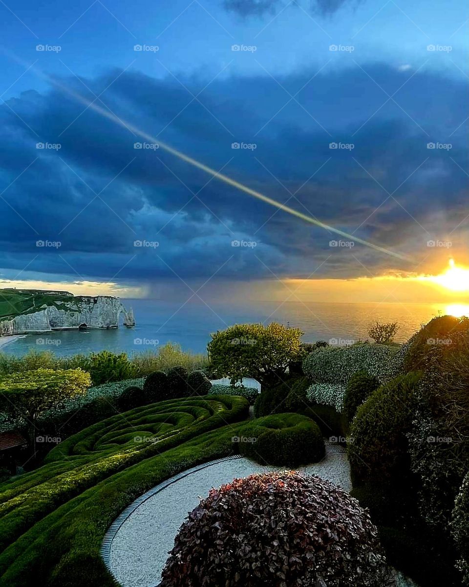 Panoramic view of the Alabaster's coast's cliffs and of the Channel from the neo-futuristic Etretat's gardens under a blue and yellow sunrise's colour explosion