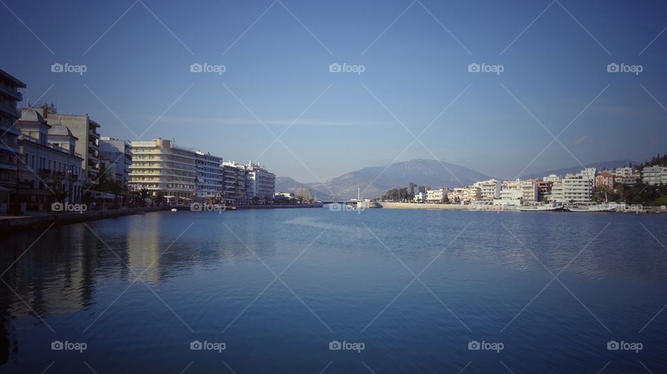 Buildings and mountain reflecting on sea, Greece