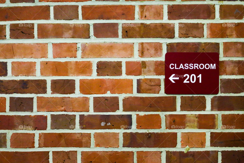 Sign to a classroom on a brick wall