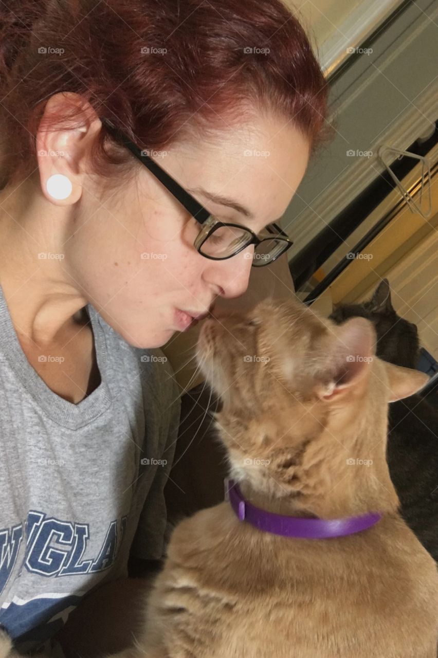 Woman kissing cat