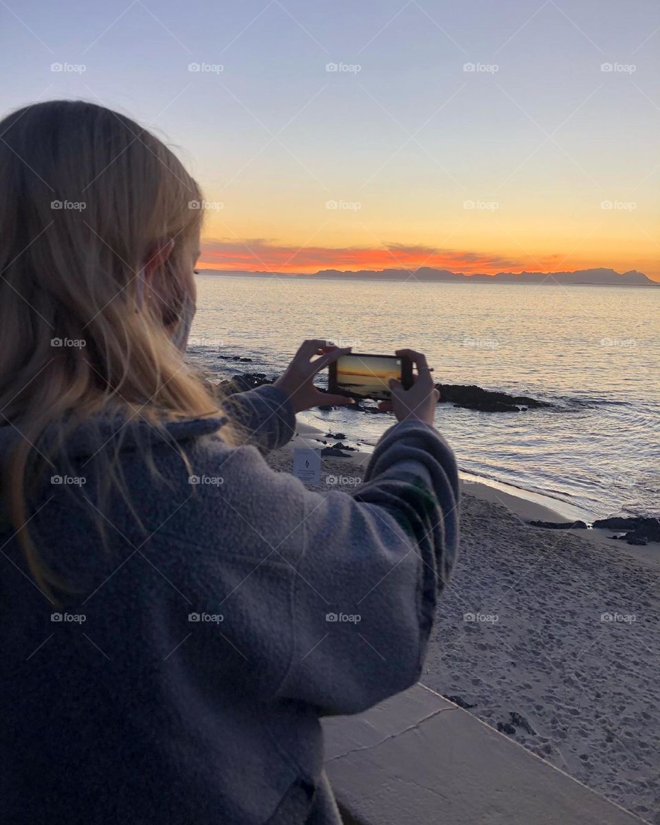 A picture of my sister taking a picture of the sunset in Cape Town 