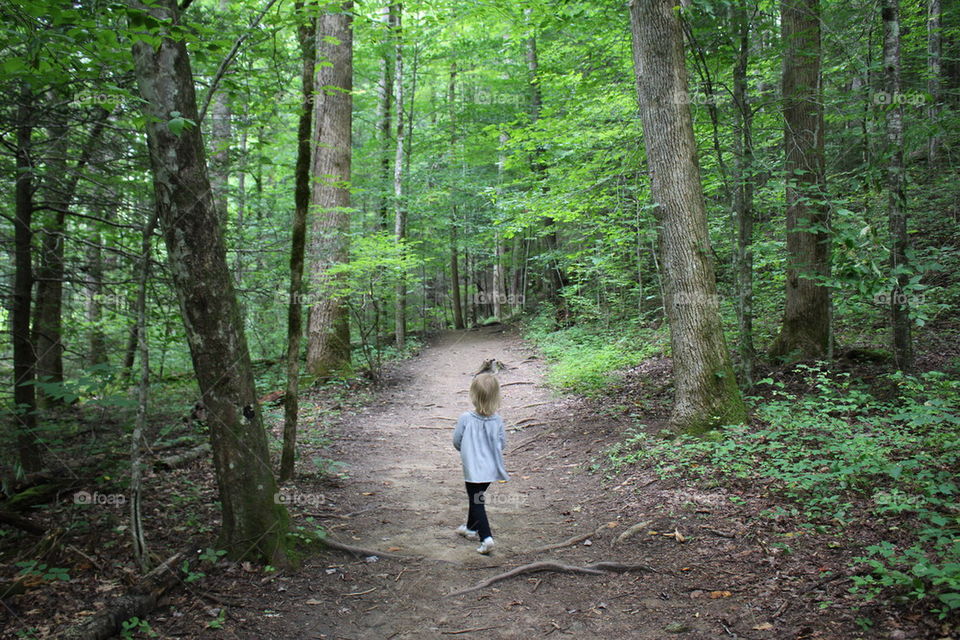 One baby girl walking in the road