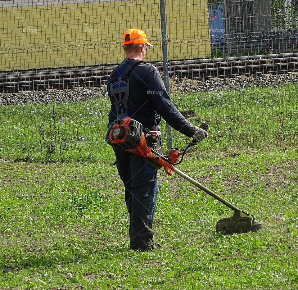 People at work. Grass cutter lawnmower man.