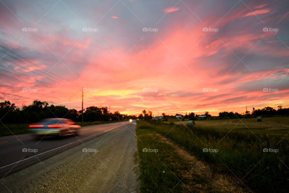 Road trip and a summer sky at sunset in the countryside 