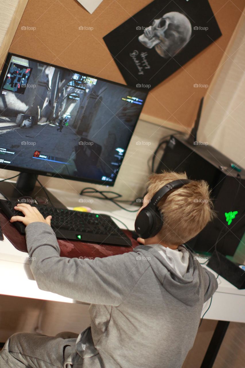 boy playing a video game on a desktop computer