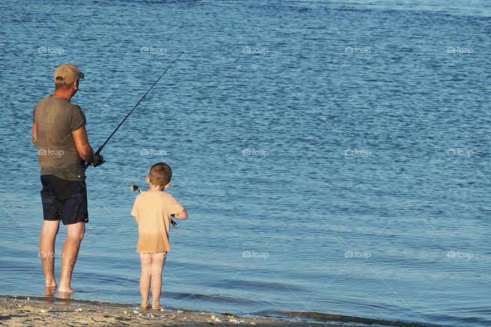 Young boy fishing with his father
