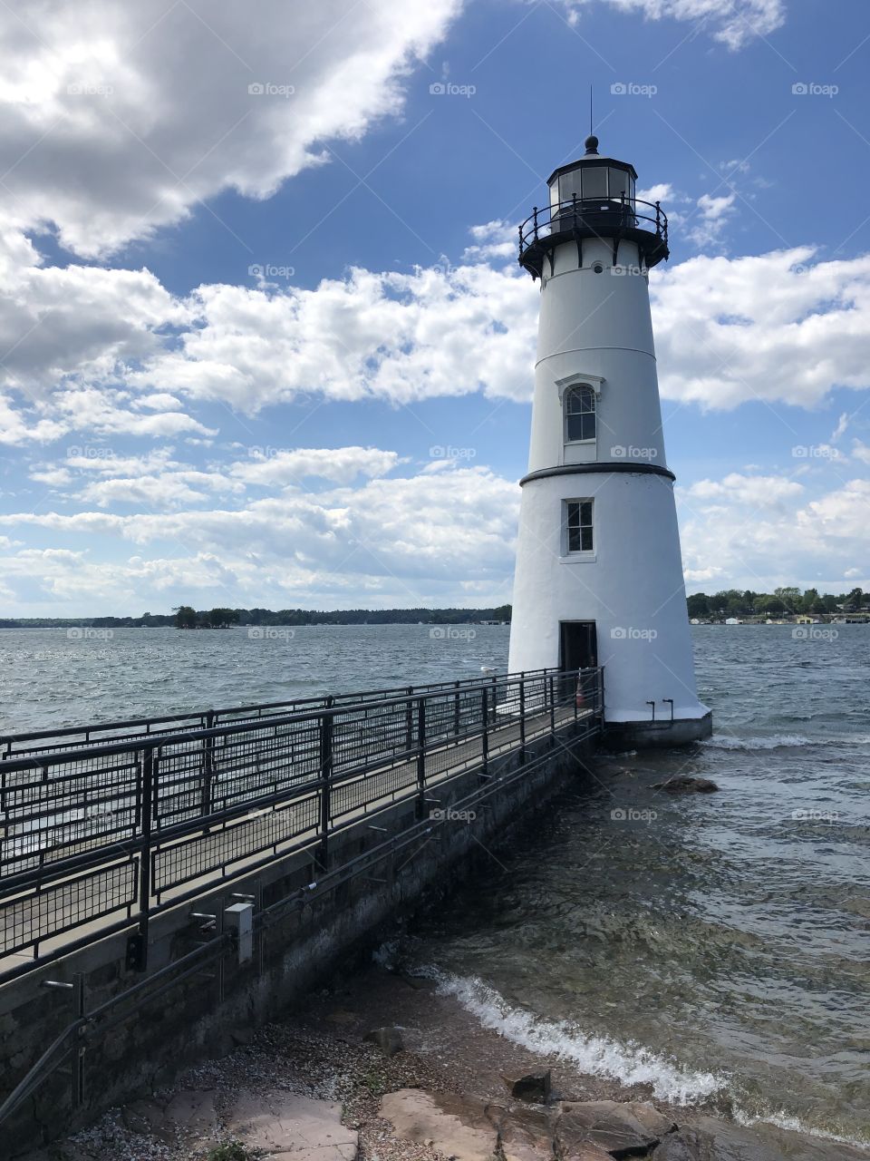 simple light house in front of a large body of water