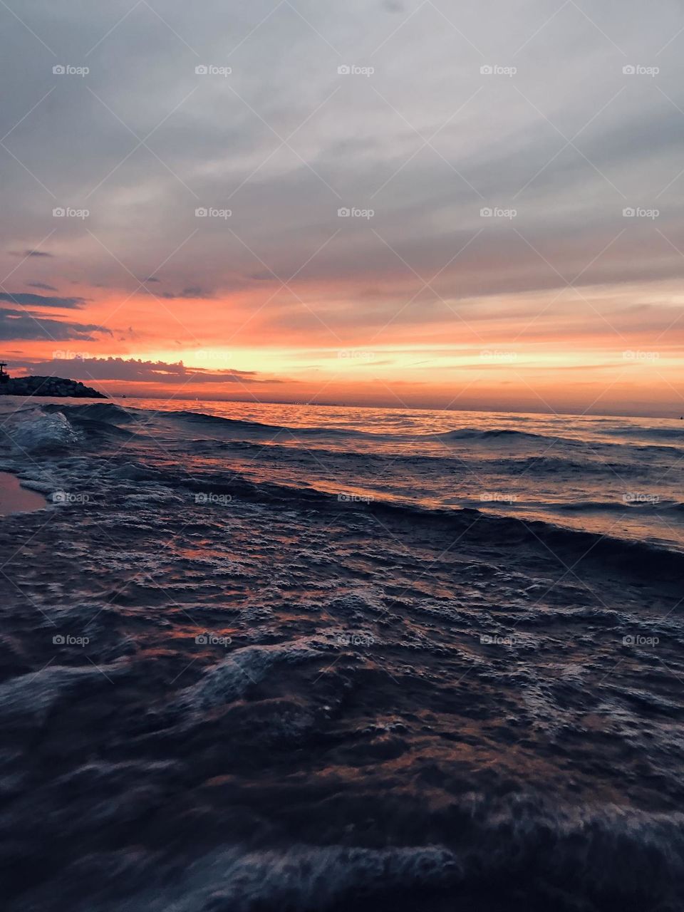 Sunset and white waves crashing the shore
