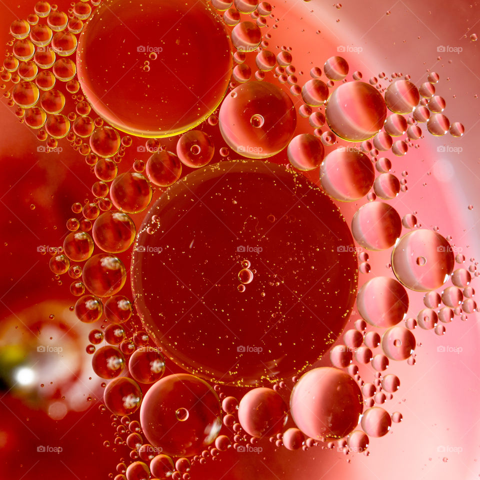 Circles of oil in water. Abstract red background